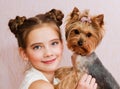 Smiling little girl child schoolgirl holding and playing with pet dog yorkshire terrier Royalty Free Stock Photo