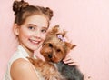 Smiling little girl child schoolgirl holding and playing with pet dog yorkshire terrier Royalty Free Stock Photo