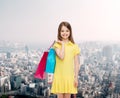 Smiling little girl in dress with shopping bags Royalty Free Stock Photo