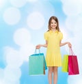 Smiling little girl in dress with shopping bags Royalty Free Stock Photo