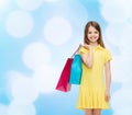 Smiling little girl in dress with shopping bags Royalty Free Stock Photo