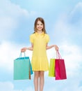 Smiling little girl in dress with shopping bags Royalty Free Stock Photo