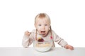 Smiling little girl eating flakes. Isolated on white background Royalty Free Stock Photo