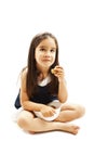 Smiling little girl eating cookie or biscuit, looking up