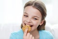 Smiling little girl eating cookie or biscuit Royalty Free Stock Photo