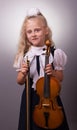 Smiling little girl in elegant clothes playing violin Royalty Free Stock Photo