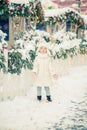 A smiling little girl at the winter fair. Wearing white coat. Royalty Free Stock Photo