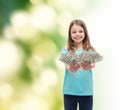 Smiling little girl giving dollar cash money