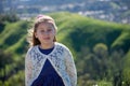 Smiling Little Girl with Green Hill Countryside Background