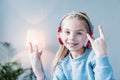 Smiling little girl in headphones showing rock signs Royalty Free Stock Photo