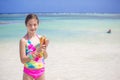 Smiling little girl holding a seashell on a scenic beach Royalty Free Stock Photo