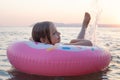 Smiling little girl on inflatable ring looking at camera. Child on sea beach Royalty Free Stock Photo
