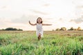 Smiling little girl joyfully running across field. Happy carefree child on grassy meadow. Outdoor walking. Royalty Free Stock Photo