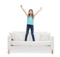 Smiling little girl jumping or dancing on sofa Royalty Free Stock Photo