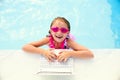 Smiling little girl learning with laptop in pool Royalty Free Stock Photo