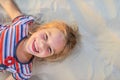 Smiling little girl lies on beach sand Royalty Free Stock Photo