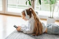 Little girl listening music lying on the floor Royalty Free Stock Photo