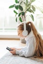 Little girl listening music lying on the floor Royalty Free Stock Photo