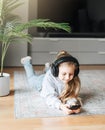 Little girl listening music lying on the floor Royalty Free Stock Photo