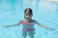 Smiling little girl looking at camera in an outdoor pool Royalty Free Stock Photo