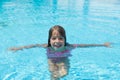 Smiling little girl looking at camera in an outdoor pool Royalty Free Stock Photo