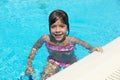 Smiling little girl looking at camera in an outdoor pool Royalty Free Stock Photo