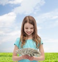 Smiling little girl looking at dollar cash money Royalty Free Stock Photo