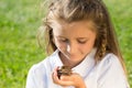 Smiling little girl looking on a large snail in Royalty Free Stock Photo