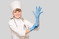 Smiling little girl in medical uniform and protects hands with sterile gloves looking at camera isolated on white Royalty Free Stock Photo