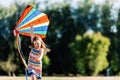 Smiling little girl playing with a colorful kite in the park. Royalty Free Stock Photo