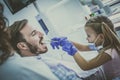 Little girl playing with her father at dentist office. Royalty Free Stock Photo