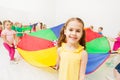 Smiling little girl playing parachute games in gym Royalty Free Stock Photo