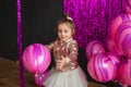 Smiling little girl plays with pink balloons at studio Royalty Free Stock Photo