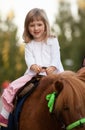 Smiling little girl on a pony Royalty Free Stock Photo