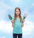 Smiling little girl with rake and scoop