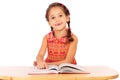 Smiling little girl reading book on the desk Royalty Free Stock Photo