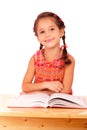 Smiling little girl reading book on the desk Royalty Free Stock Photo