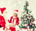 Smiling little girl with santa claus and gifts Royalty Free Stock Photo