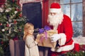 Smiling little girl with Santa Claus and gifts Royalty Free Stock Photo