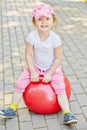 Smiling little girl sits on red ball for jumping Royalty Free Stock Photo