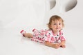 Smiling little girl sitting on the floor on a white background Royalty Free Stock Photo