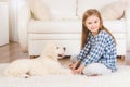 Girl sitting with retriever puppy at home Royalty Free Stock Photo