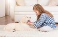 Girl sitting with retriever puppy at home Royalty Free Stock Photo