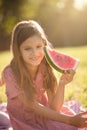 Smiling little girl sitting in nature and eating watermelon Royalty Free Stock Photo