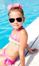 Smiling little girl sitting near swimming pool Royalty Free Stock Photo