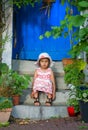 Smiling little girl sitting on stairs of house barefoot Royalty Free Stock Photo