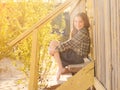 Smiling little girl sitting on wooden stairs barefoot Royalty Free Stock Photo