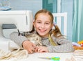 Smiling little girl at the table with sewing Royalty Free Stock Photo