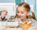 Smiling little girl at the table with sewing Royalty Free Stock Photo