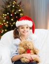 Smiling little girl with teddy bear on christmas